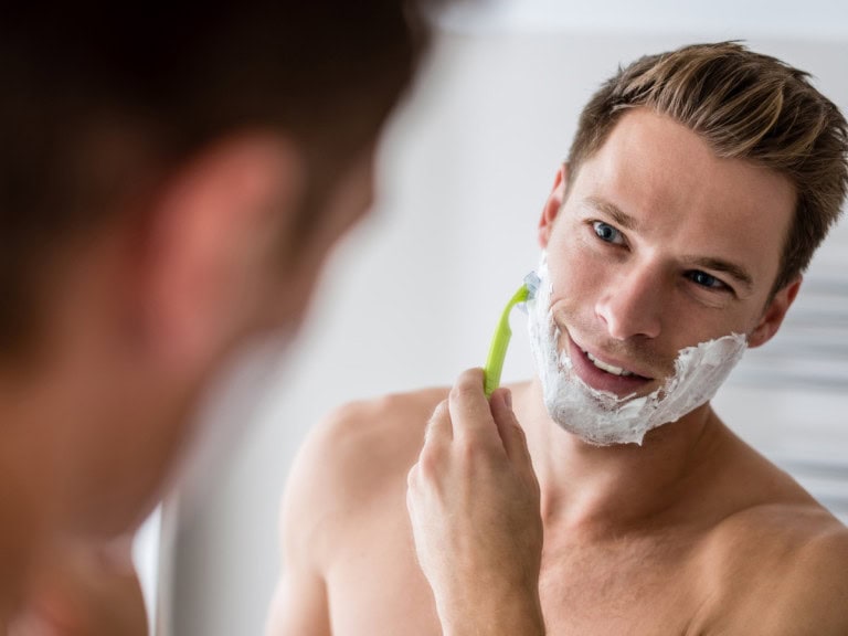 man shaving his beard