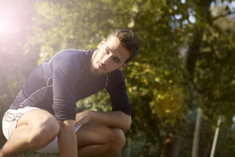 young-bearded-man-crouching-in-park