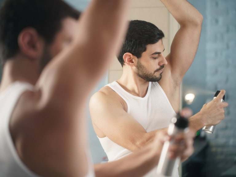 Men applying deodorant