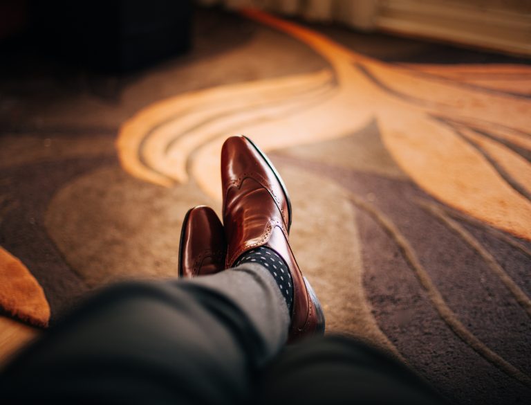 Man with dress shoes laying on rug