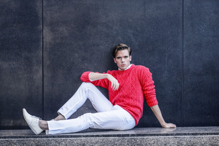 Young man wearing white pants and red sweater