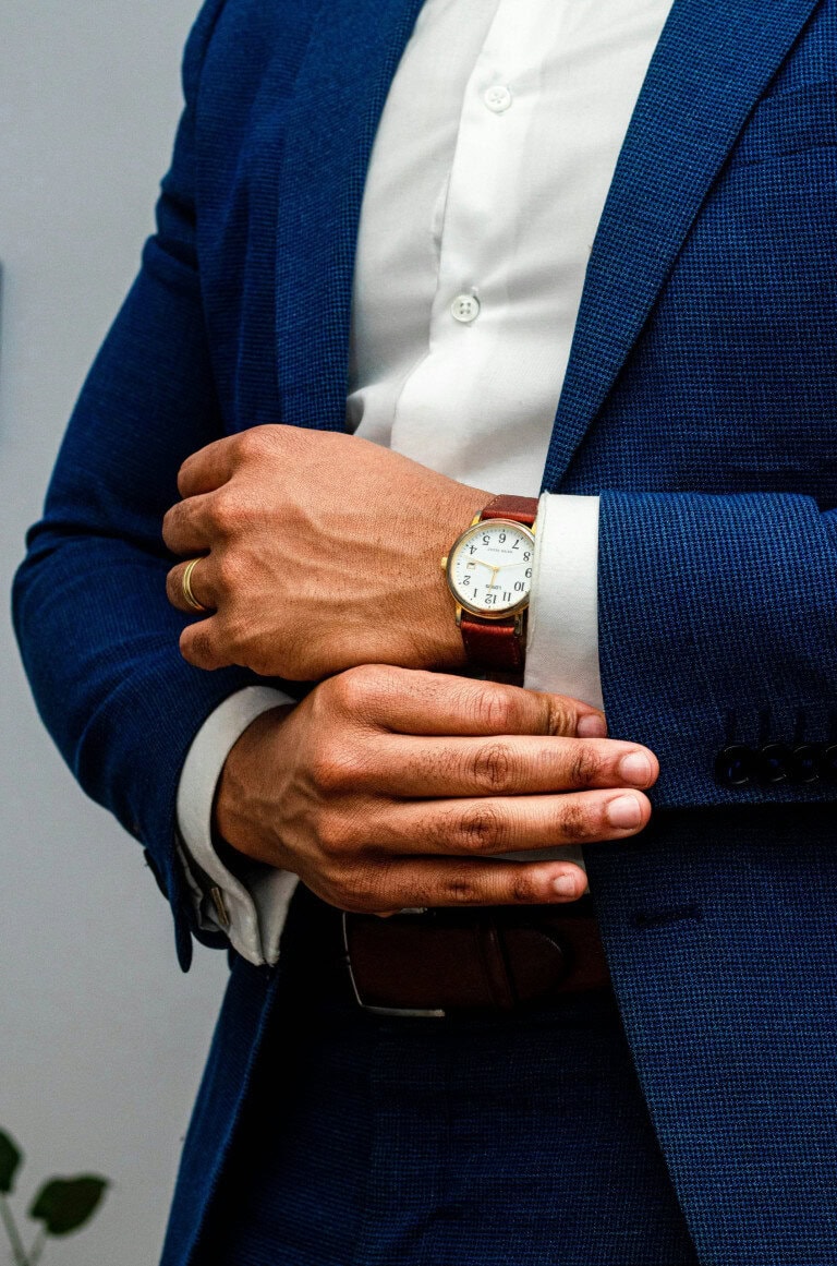 man fixing cufflinks navy suit