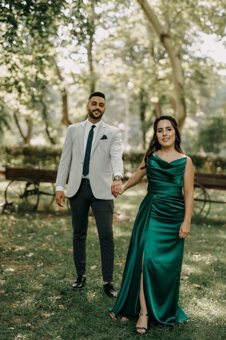 Couple in coordinated formal attire holding hands in sunlight