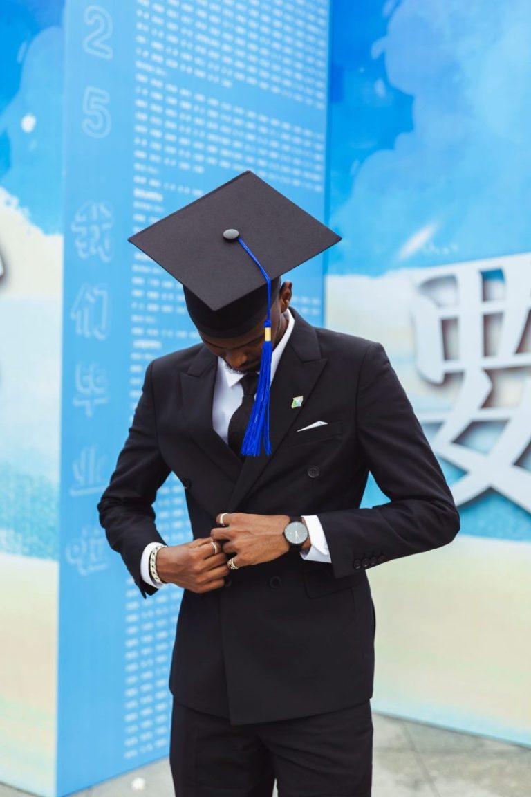 Young graduate in a suit and graduation gown
