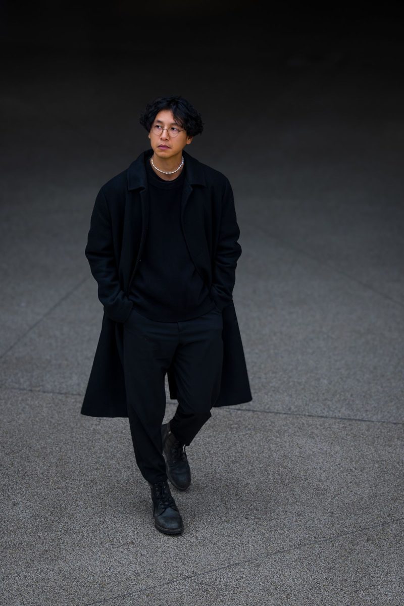 Man in a long black coat walking outdoors
