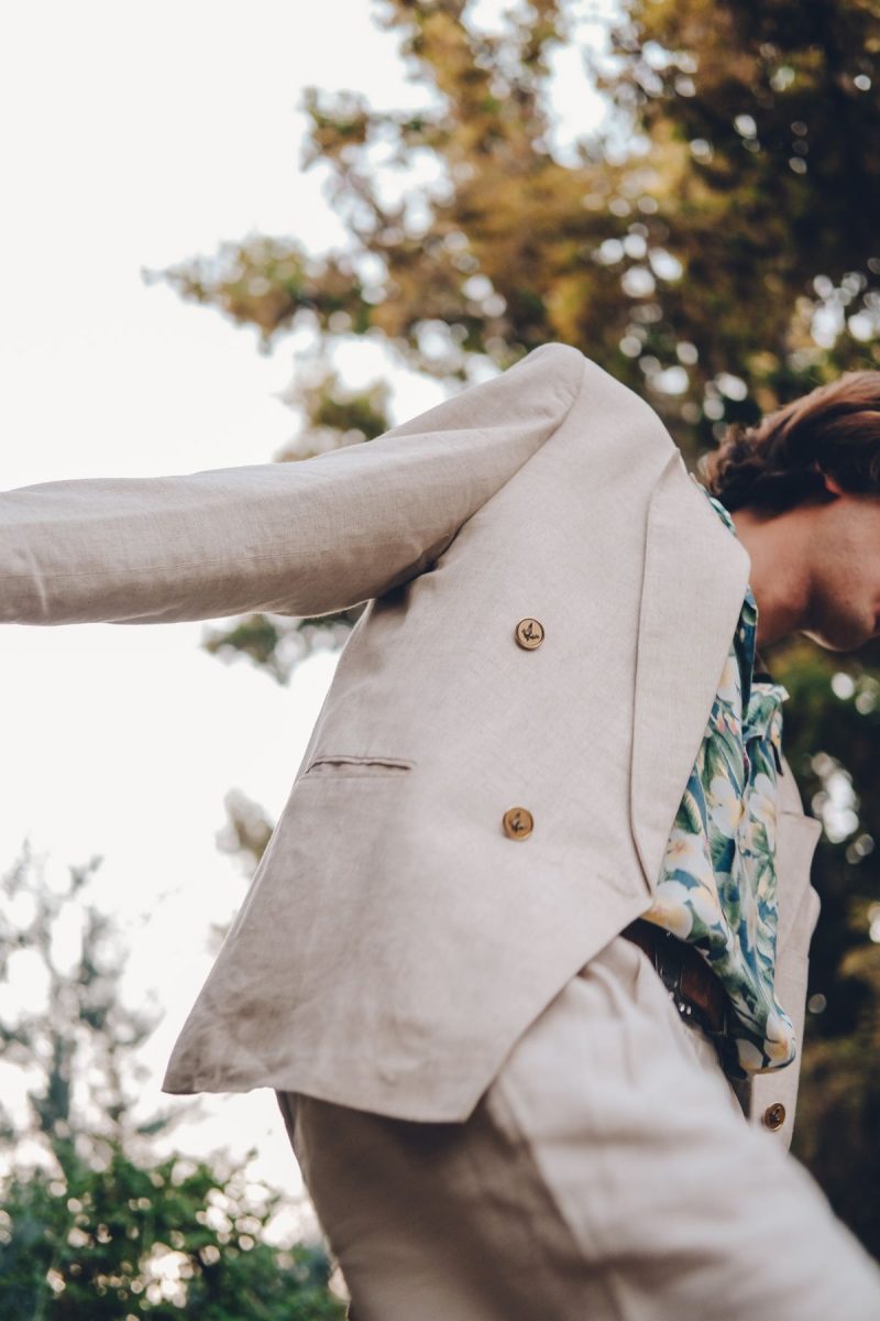 Man wearing a linen suit with a floral shirt outdoors