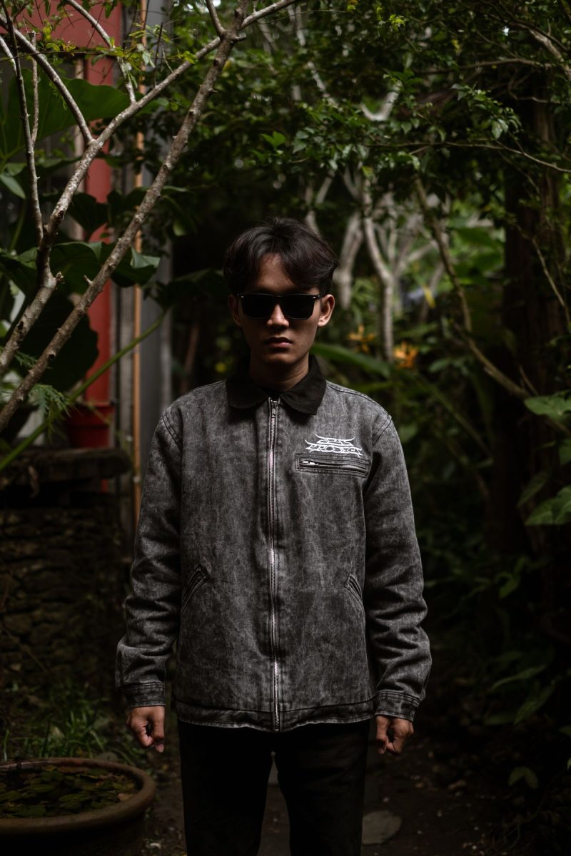 Man in a denim jacket standing in an urban garden