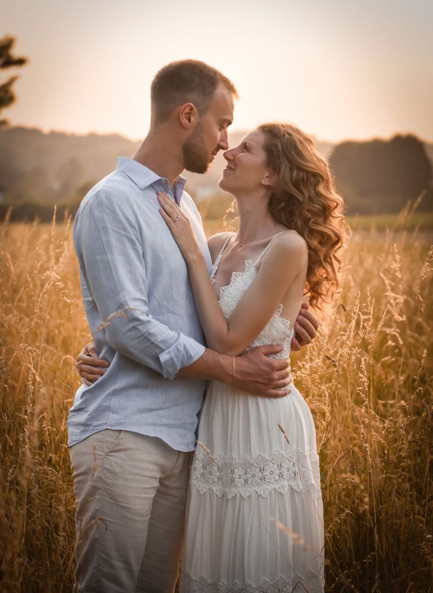 Couple in a field at golden hour, the man in a chambray shirt